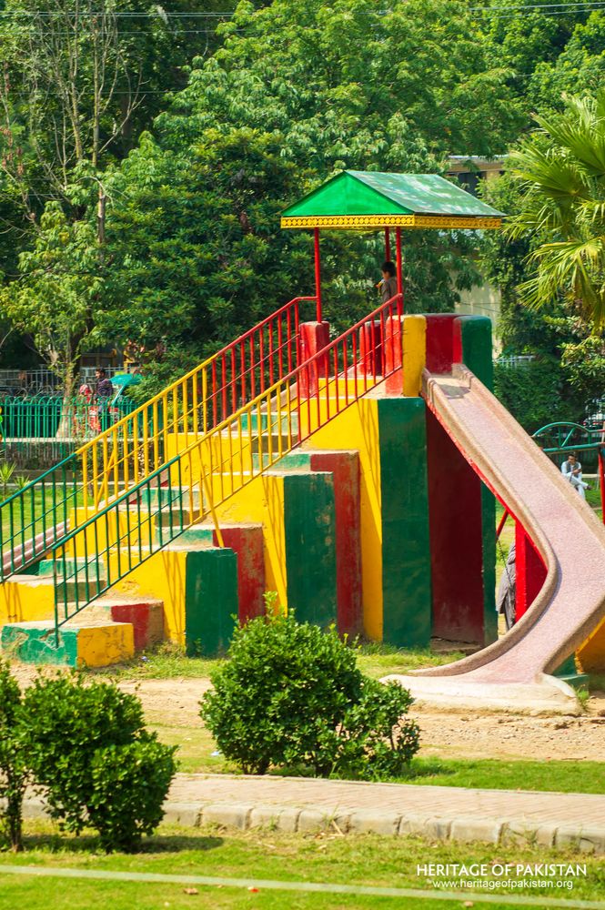 Children's play area features bright primary colors amid Lady Garden Park greenery.